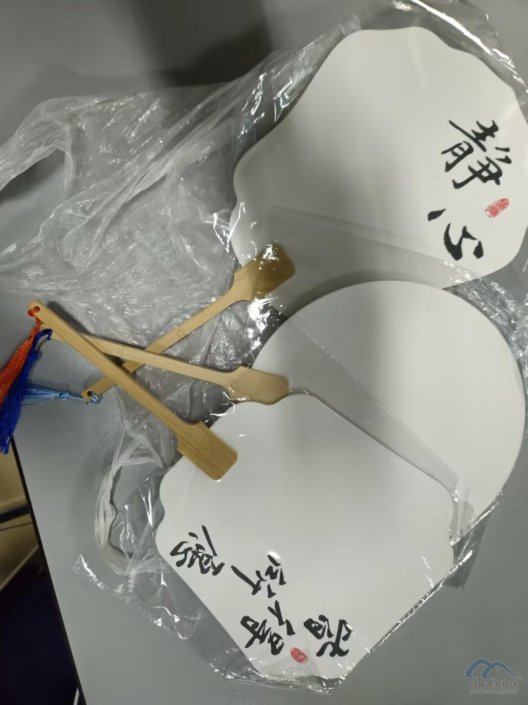 一个透明塑料袋，内有三把扇子.jpg